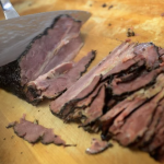 Pastrami being hand-cut on the board at Langer's Deli